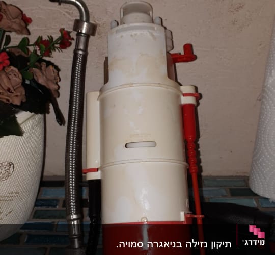 צינור מתכת גמיש ליד מכשיר פלסטיק לבן ואדום